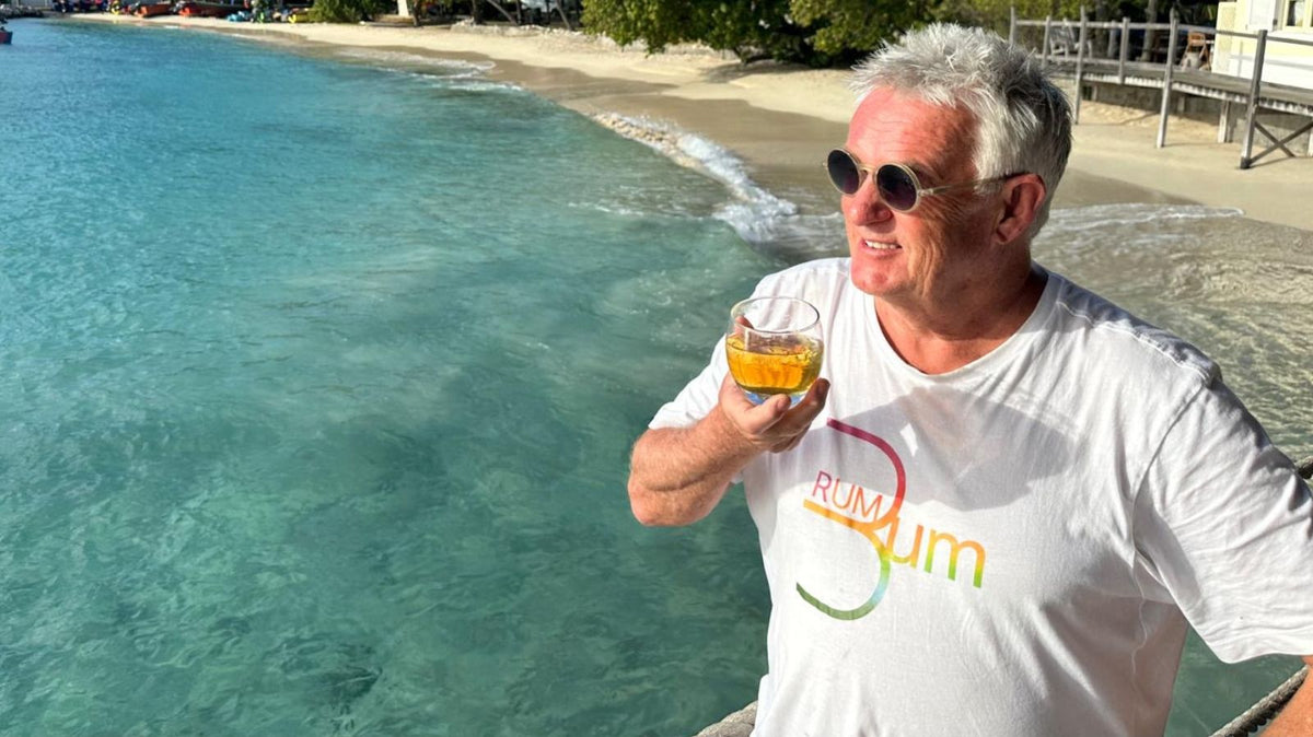 Kevin Snooky sipping a rum cocktail by the Caribbean sea