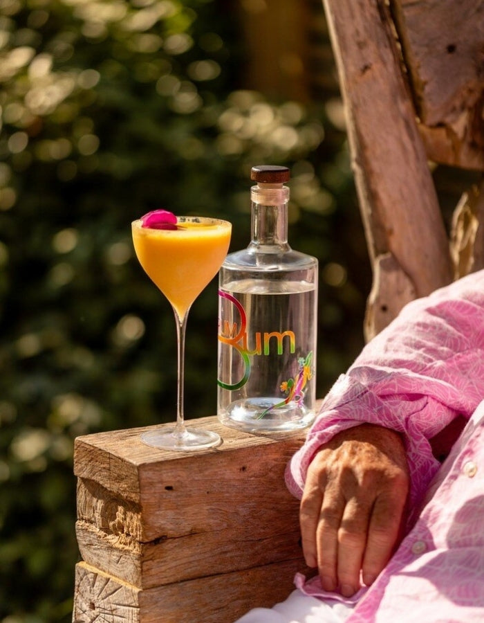 Rum Bum Signature Rum beside a tropical cocktail