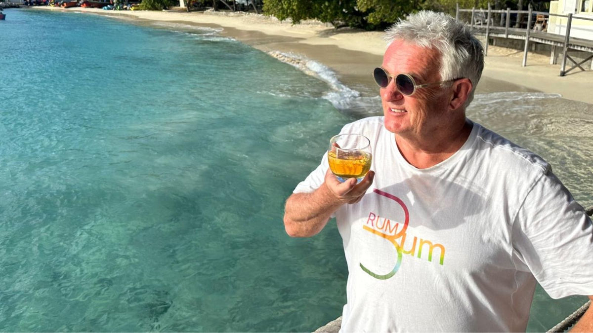 Kevin Snooky sipping a rum cocktail by the Caribbean sea