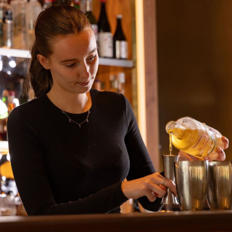 Anya Garrow pours rum while preparing a cocktail during the Rising Stars Challenge