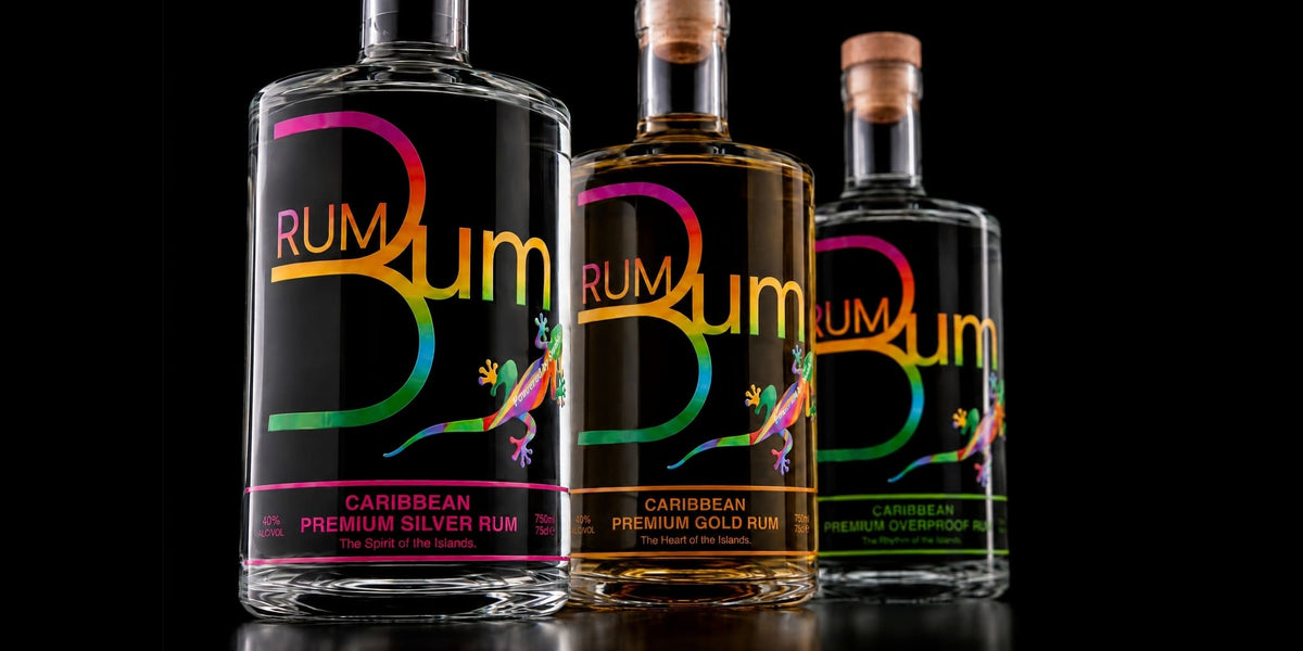 Three Rum Bum Caribbean rum bottles. Silver gold and overproof varieties on a black background.