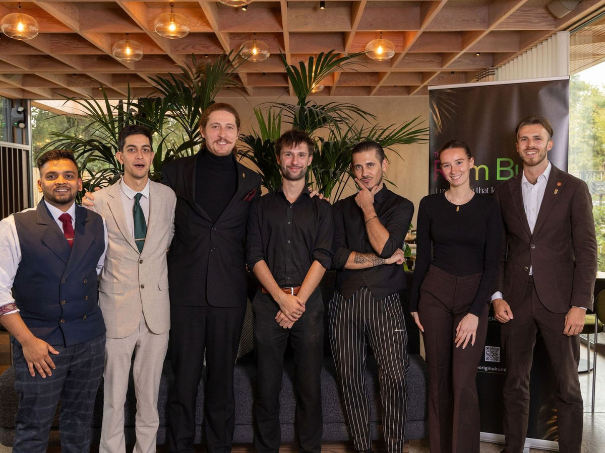 seven finalist bartenders pose together beside a Rum Bum banner at The Braywood