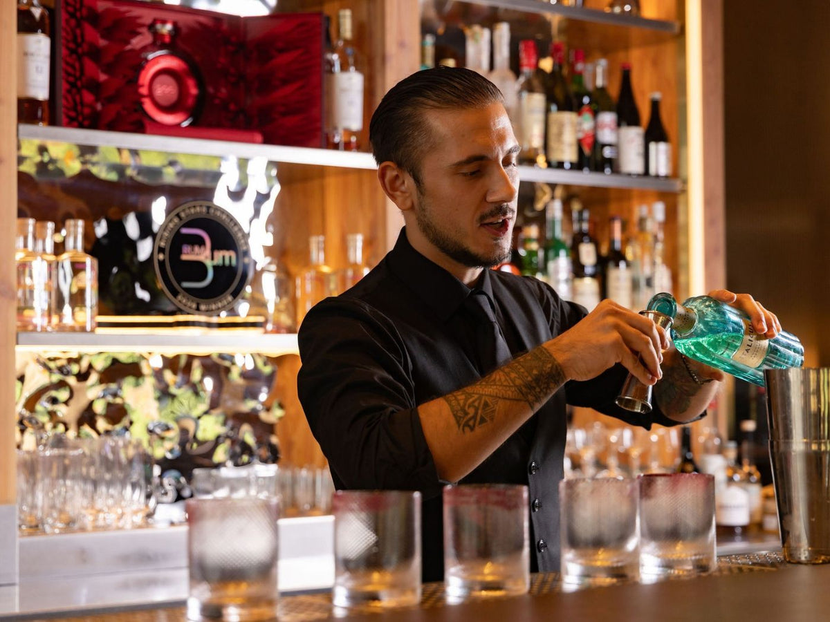 Rising Stars finalist measures a spirit into a cocktail shaker