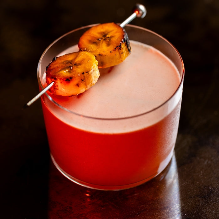 J’Ouvert rum cocktail garnished with grilled banana