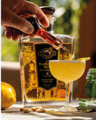 Rum Almond Sour cocktail with a lemon garnish