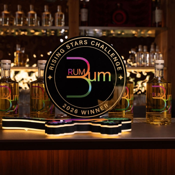 2026 Rising Stars Challenge winner trophy by The Original Rum Bum on a bar with rum bottles.